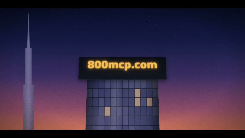 The 800mcp.com sign, lit, on top of a tower at dusk.